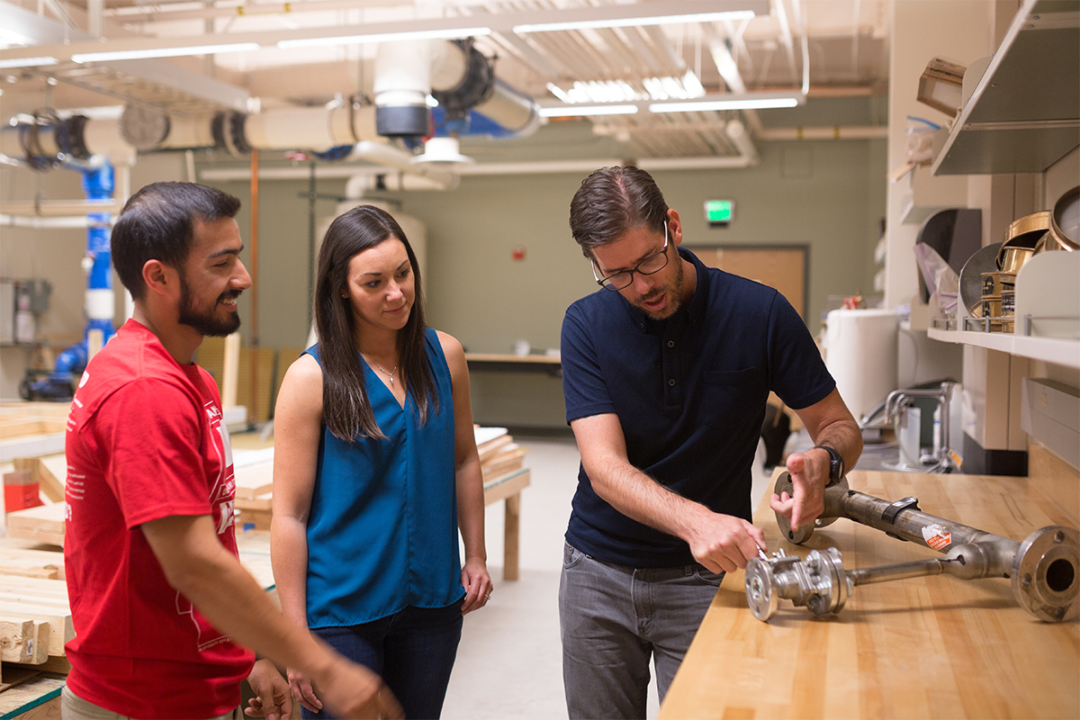 photo of professor MArk Stone with students in laboratory