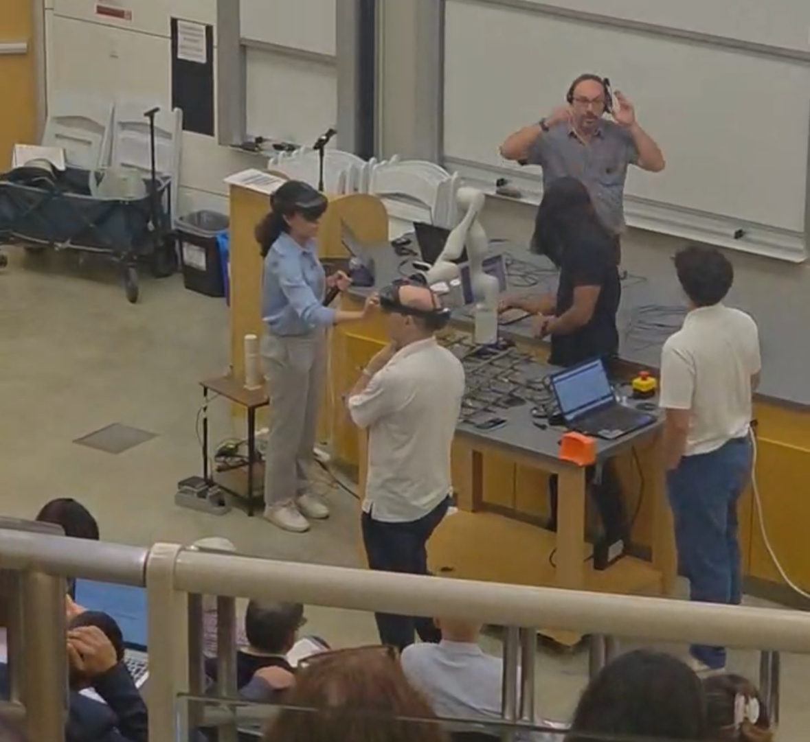 photo: The UNM team during the SHM in Action demonstration at Stanford. The team shows the audience a real-time human-in-the-loop Kinova Arm control during construction.